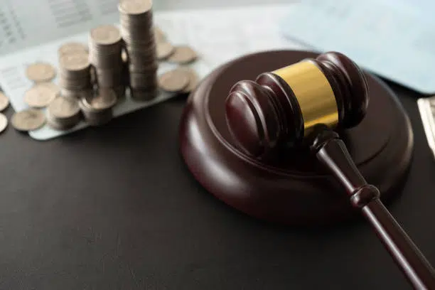 Judge's gavel next to a small amount of cash.
